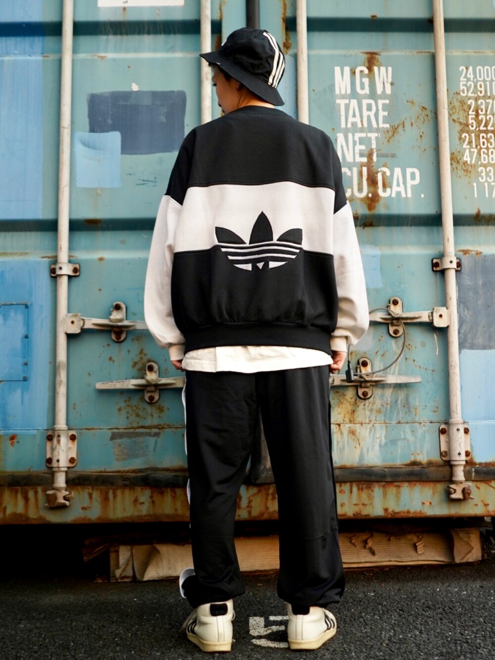 ブラック系のスウェット、ホワイト系のスニーカー、ブラック系のその他パンツを着用したレディースの冬コーディネートの2枚目の写真