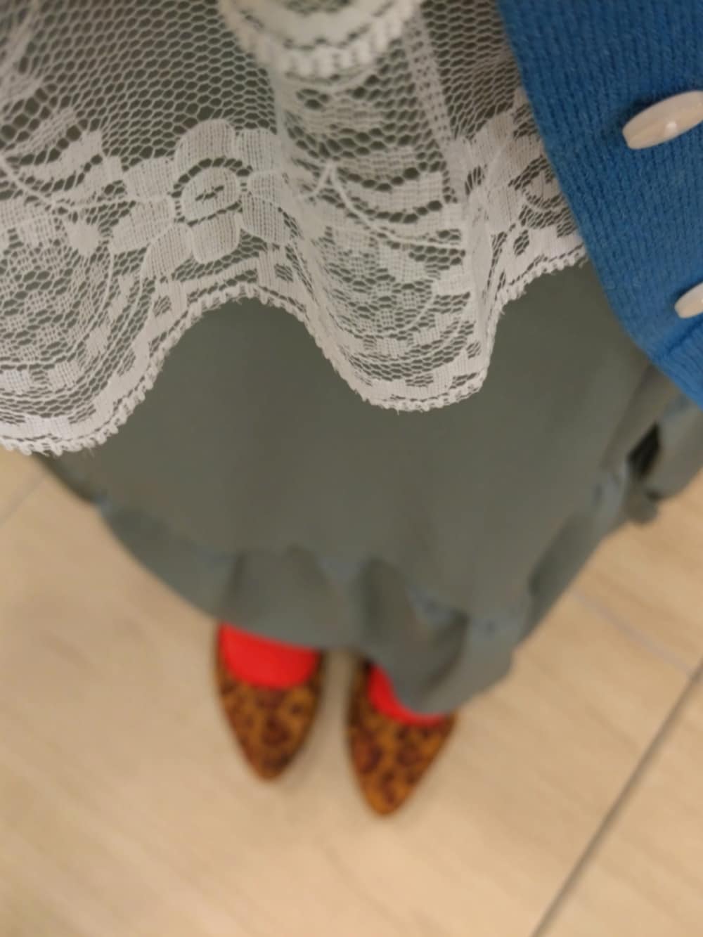 ブルー系のカーディガン/ボレロ、グリーン系のスカート、ブラウン系のシューズを着用したレディースの秋コーディネートの2枚目の写真