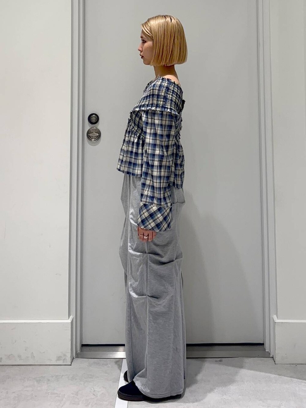 グレー系のスカート、ブラック系のシャツ/ブラウス、レッド系のボストンバッグを着用したレディースの春コーディネートの3枚目の写真