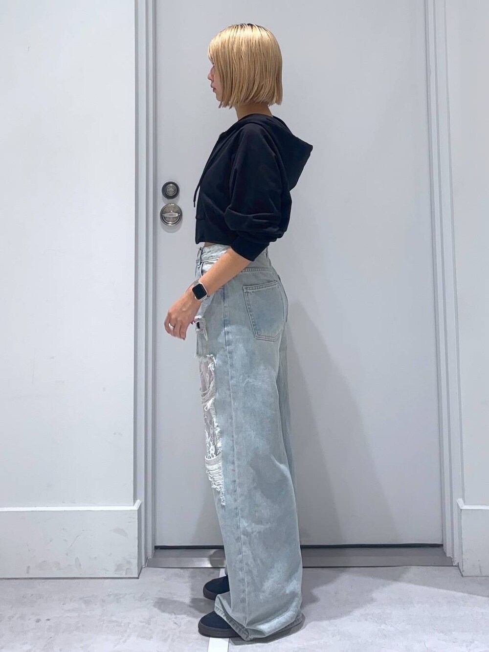 ブラック系のパーカー、ブルー系のデニムパンツを着用したレディースの秋コーディネートの4枚目の写真