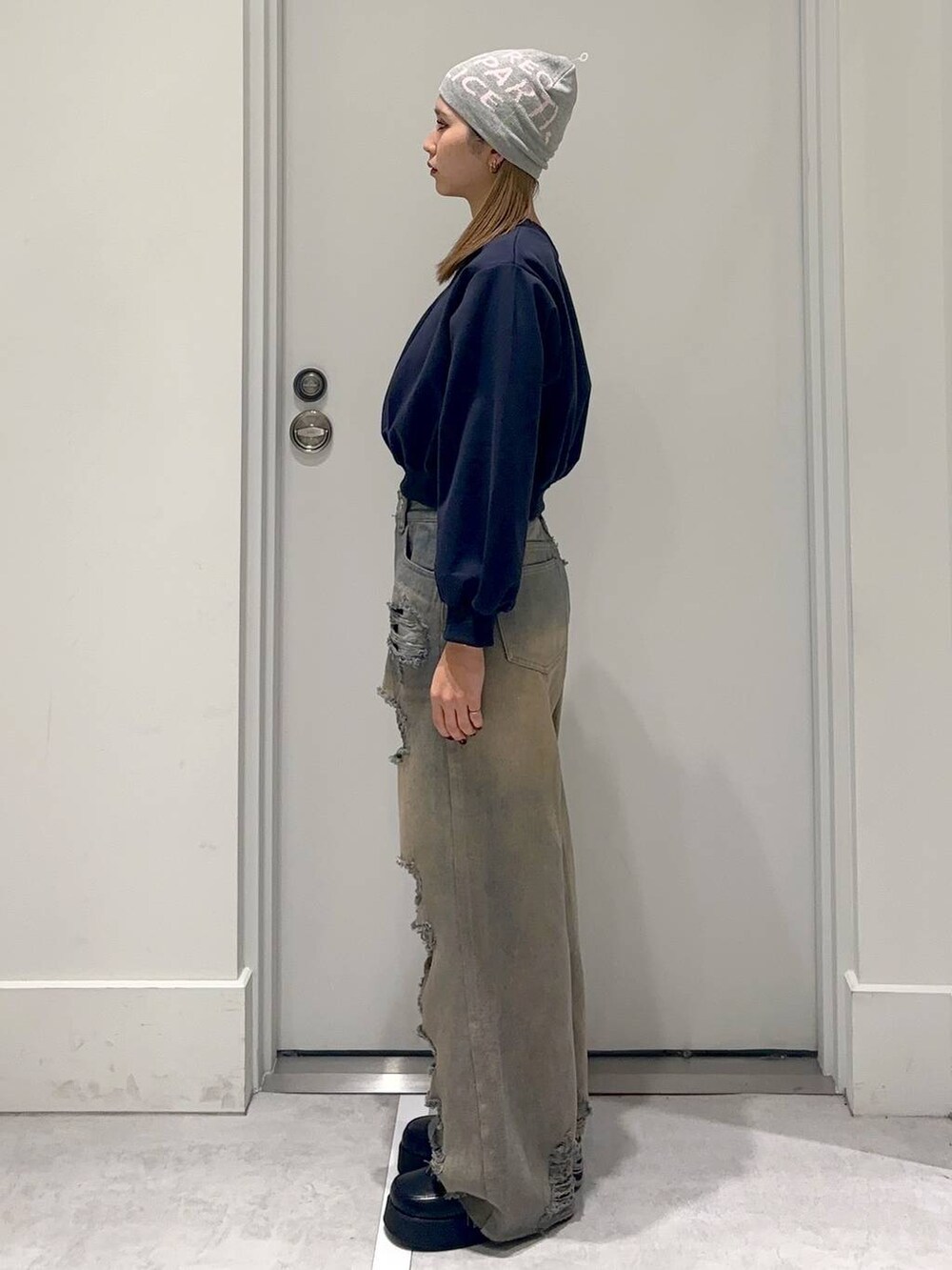 ブラック系のスリッポン、ブルー系のスウェット、ブルー系のデニムパンツを着用したレディースの冬コーディネートの3枚目の写真