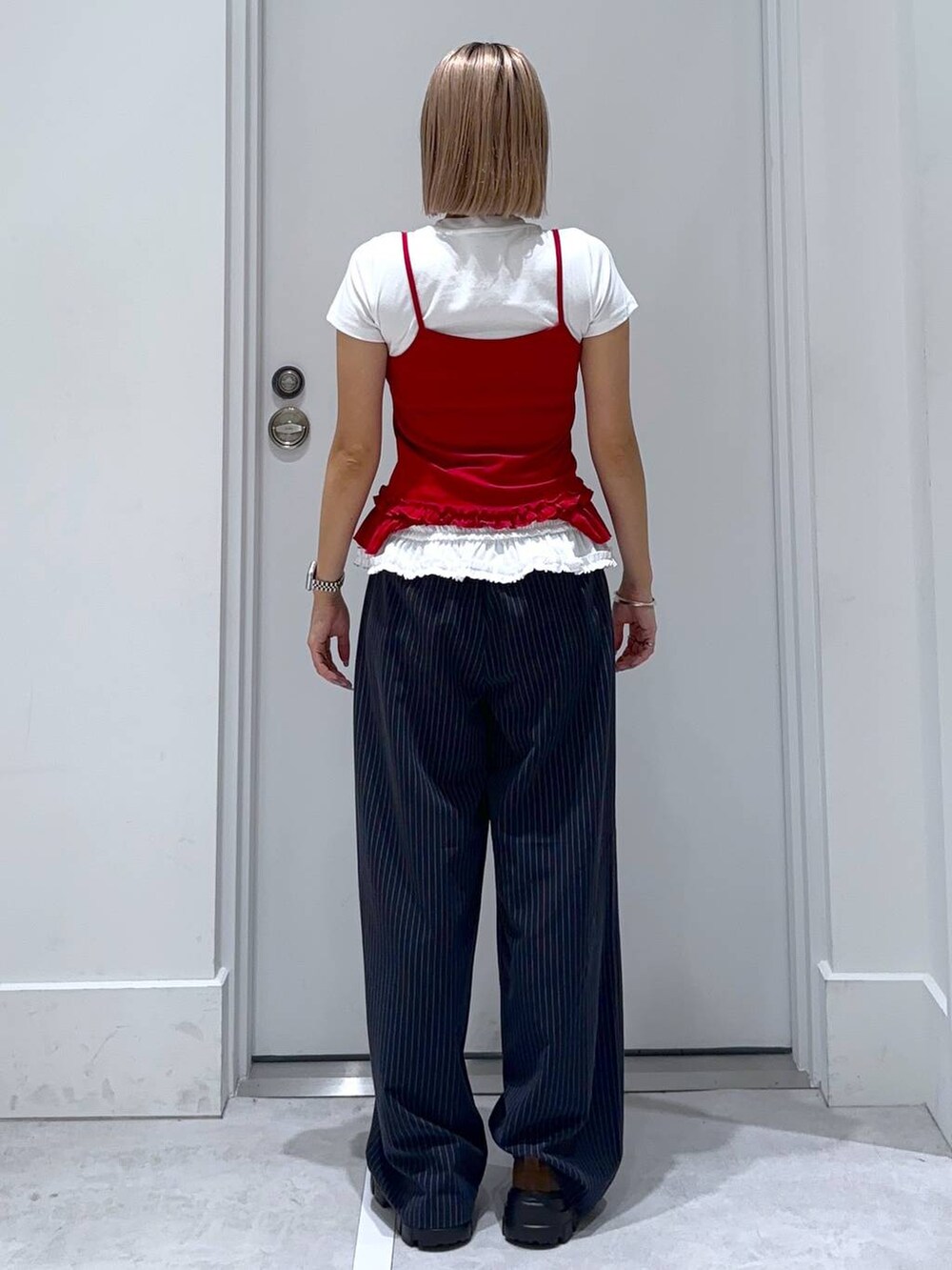 ブラウン系のモカシン/デッキシューズ、ブルー系のスラックス、ホワイト系のTシャツ/カットソーを着用したレディースの夏コーディネートの5枚目の写真