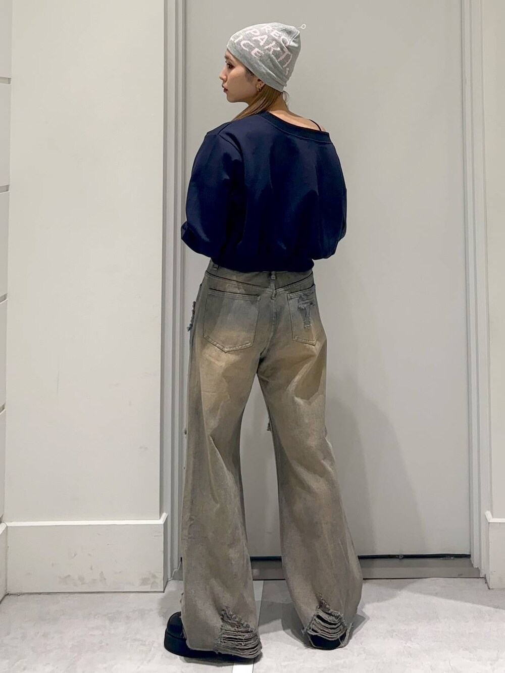 ブラック系のスリッポン、ブルー系のスウェット、ブルー系のデニムパンツを着用したレディースの冬コーディネートの4枚目の写真