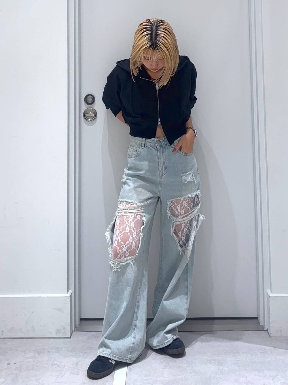 ブラック系のパーカー、ブルー系のデニムパンツを着用したレディースの秋コーディネートの2枚目の写真