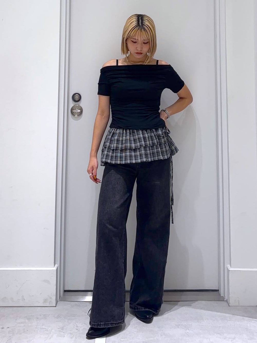 ブラック系のデニムパンツ、ブラック系のTシャツ/カットソー、ブラック系のベルトを着用したレディースの秋コーディネートの2枚目の写真