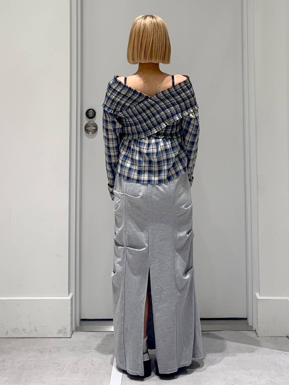 グレー系のスカート、ブラック系のシャツ/ブラウス、レッド系のボストンバッグを着用したレディースの春コーディネートの4枚目の写真