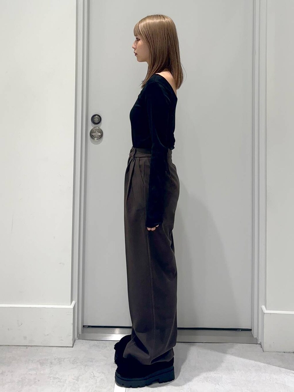 ブラック系のローファー、ブラウン系のスラックス、ホワイト系のTシャツ/カットソーを着用したレディースの冬コーディネートの2枚目の写真