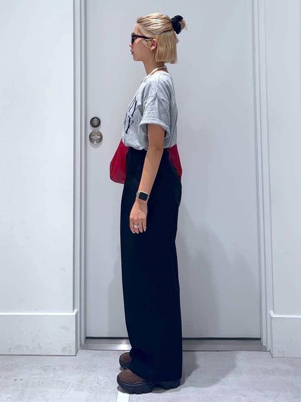 ブラウン系のモカシン/デッキシューズ、グレー系のTシャツ/カットソー、ブラック系のスラックスを着用したレディースの夏コーディネートの4枚目の写真