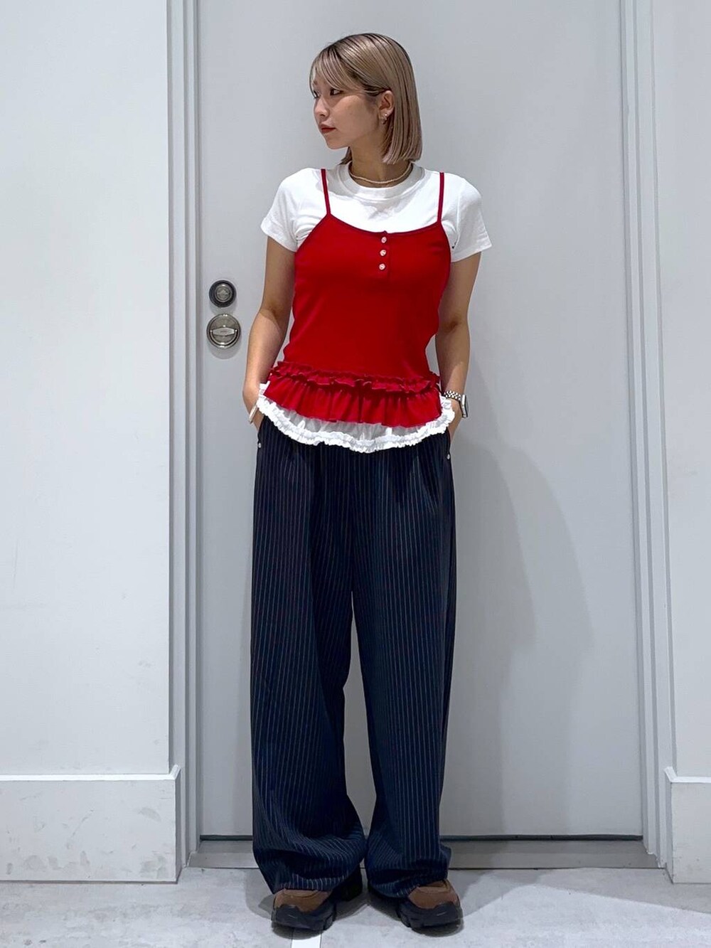 ブラウン系のモカシン/デッキシューズ、ブルー系のスラックス、ホワイト系のTシャツ/カットソーを着用したレディースの夏コーディネートの2枚目の写真