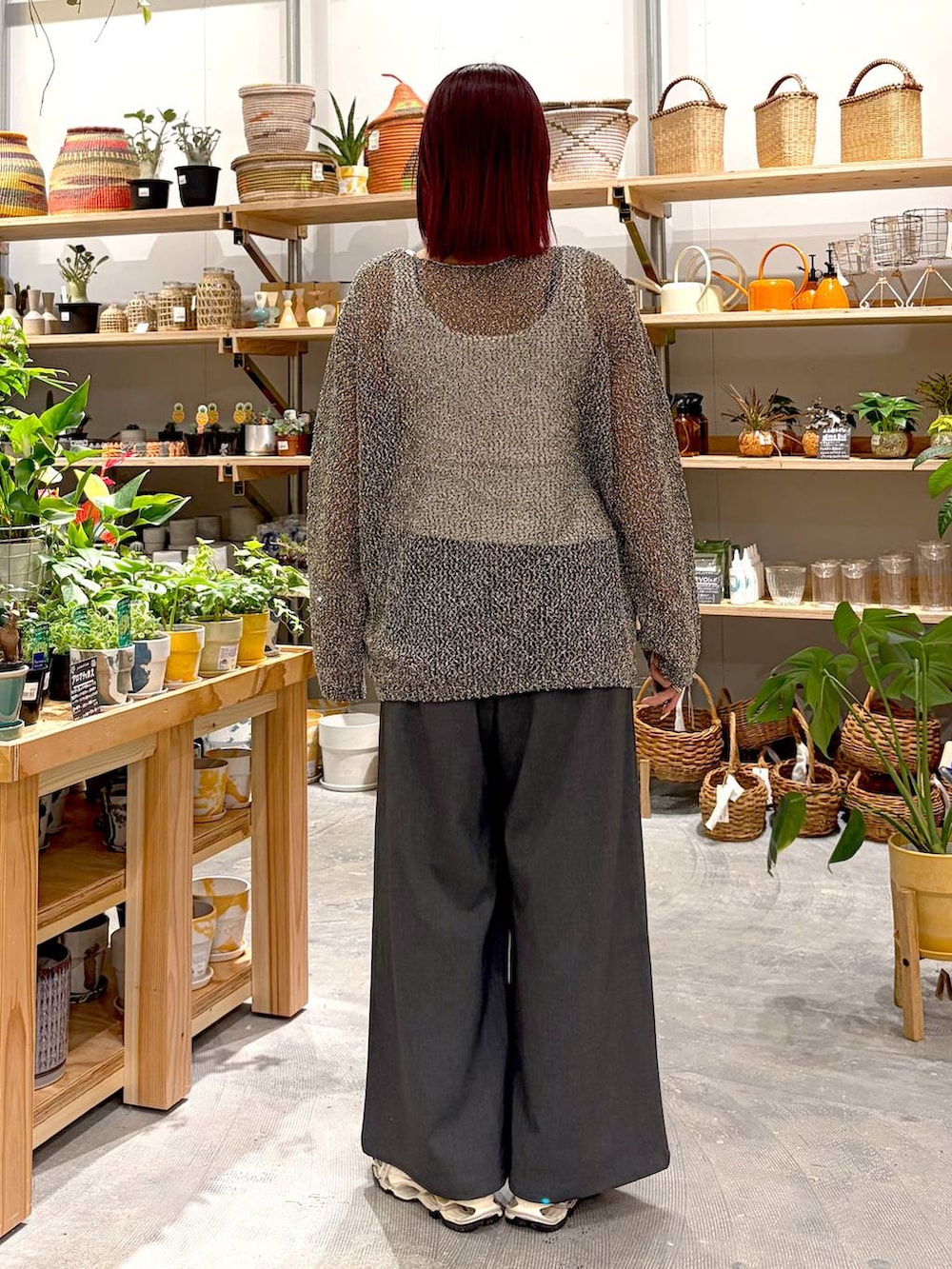 グレー系のその他パンツ、ブラック系のニット/セーター、ホワイト系のタンクトップを着用したレディースの春コーディネートの4枚目の写真