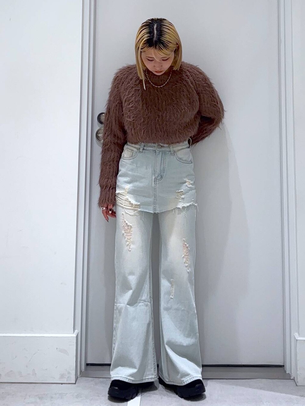 ブラウン系のニット/セーター、ブラック系のモカシン/デッキシューズ、ブルー系のデニムパンツを着用したレディースの秋コーディネートの2枚目の写真