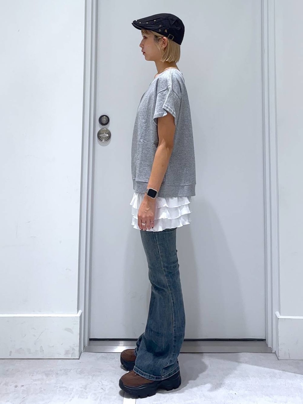 ブルー系のデニムパンツ、ブラウン系のモカシン/デッキシューズ、グレー系のセットアップを着用したレディースの秋コーディネートの3枚目の写真