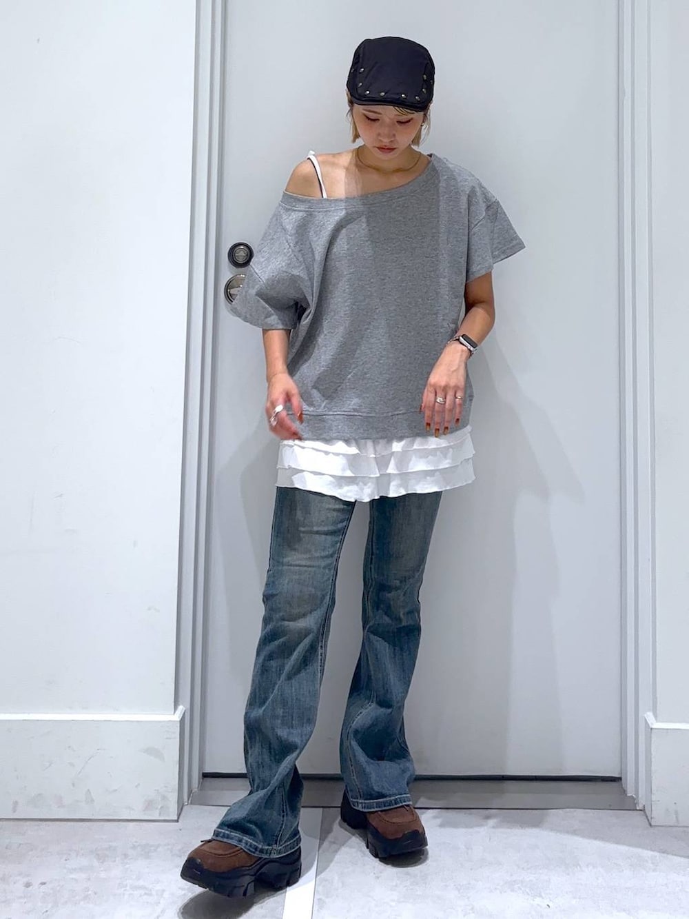 ブルー系のデニムパンツ、ブラウン系のモカシン/デッキシューズ、グレー系のセットアップを着用したレディースの秋コーディネートの2枚目の写真