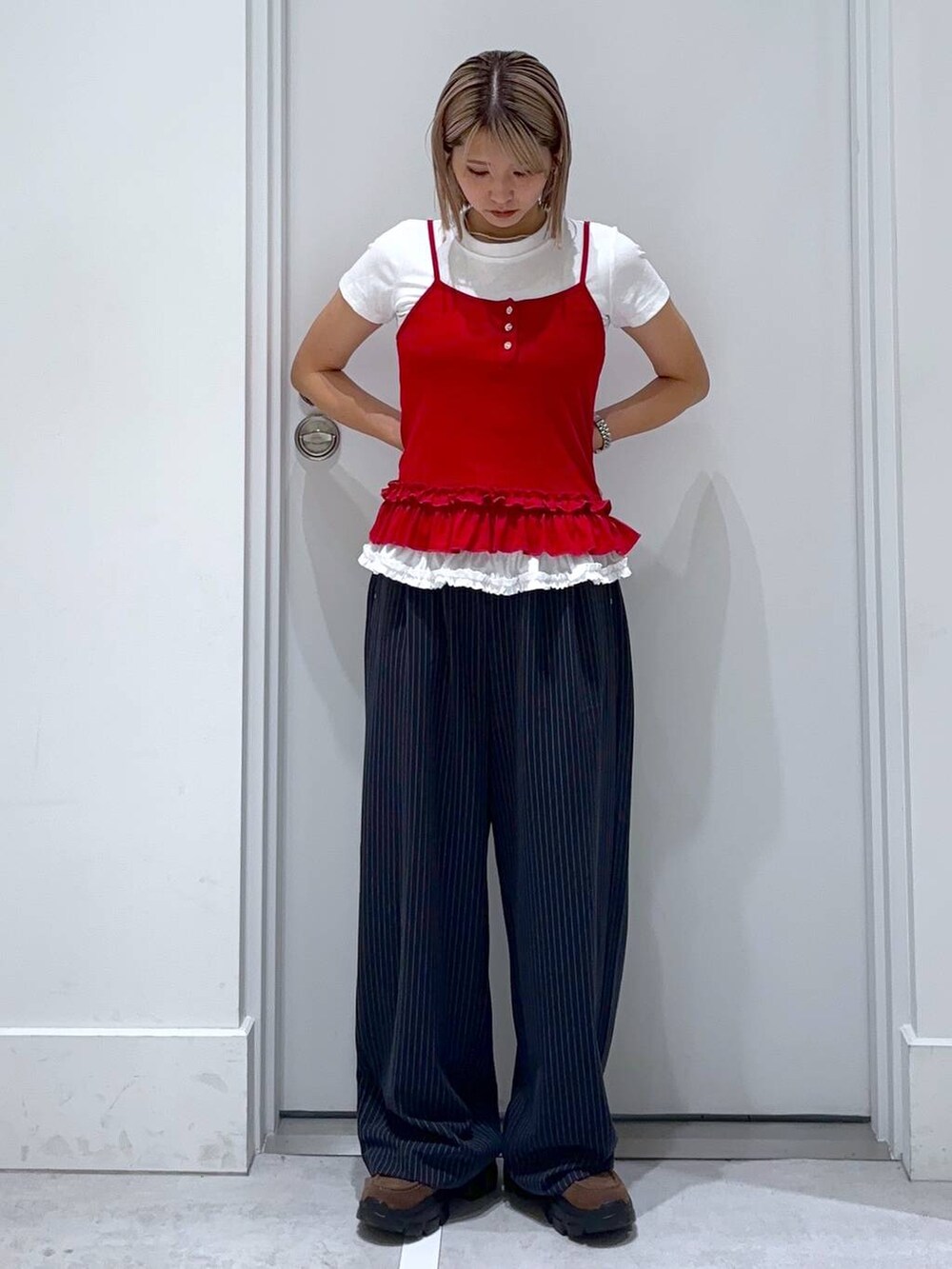 ブラウン系のモカシン/デッキシューズ、ブルー系のスラックス、ホワイト系のTシャツ/カットソーを着用したレディースの夏コーディネートの3枚目の写真
