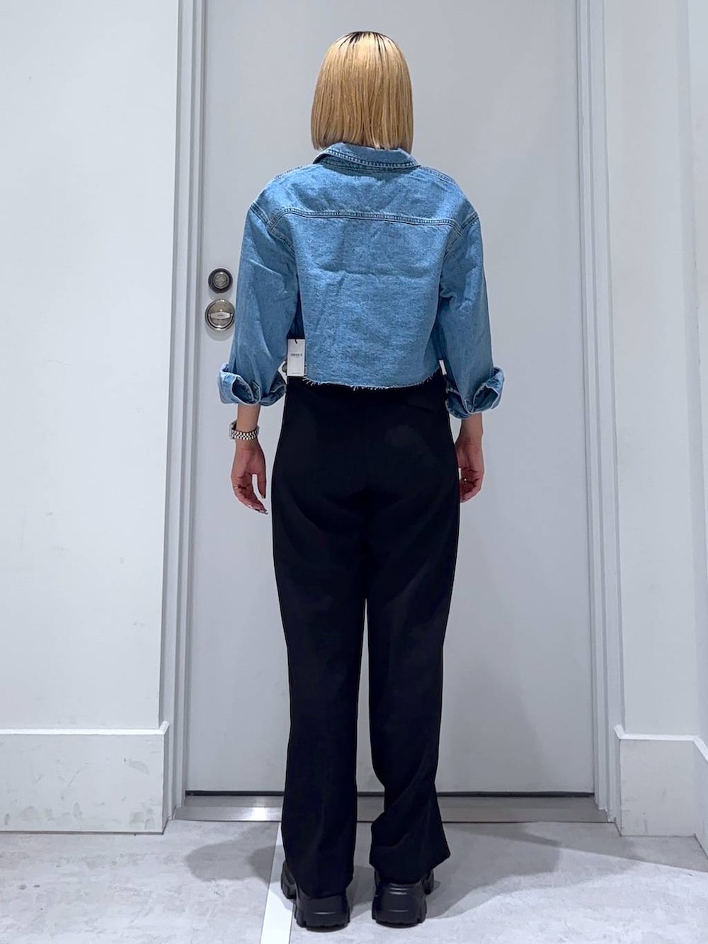 ブルー系のデニムジャケット、ブラック系のモカシン/デッキシューズ、ブラック系のスラックスを着用したレディースの秋コーディネートの4枚目の写真