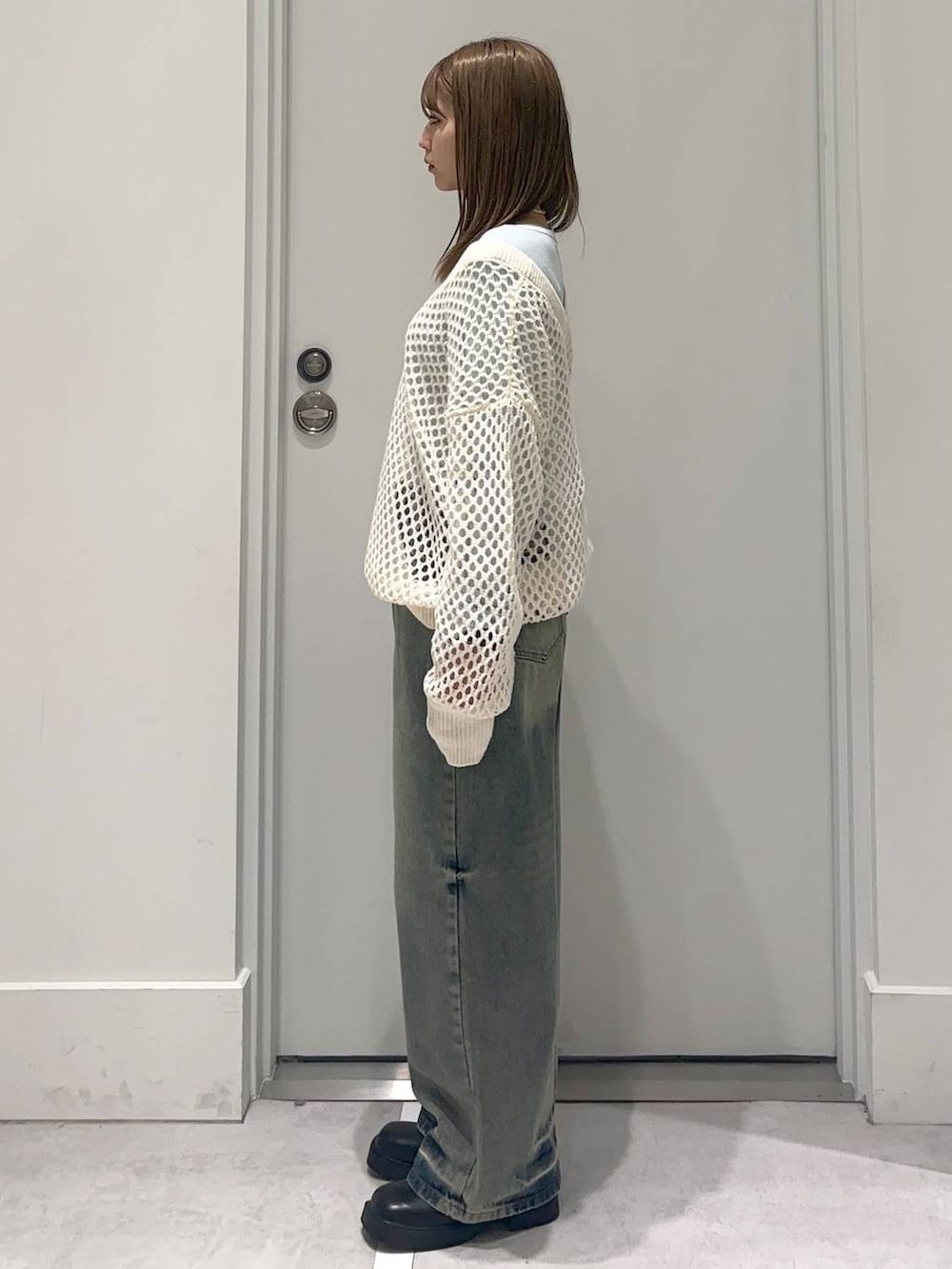 ブラック系のブーツ、ブルー系のTシャツ/カットソー、ブルー系のデニムパンツを着用したレディースの冬コーディネートの3枚目の写真