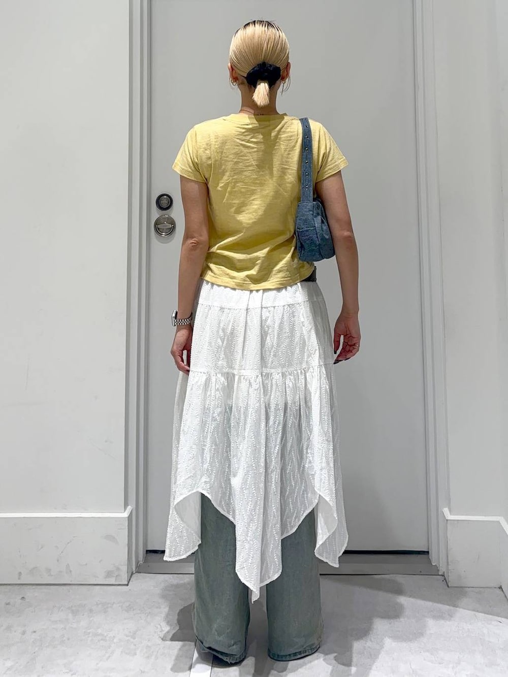 ブルー系のデニムパンツ、ブルー系のショルダーバッグ、レッド系のパンプスを着用したレディースの春コーディネートの5枚目の写真