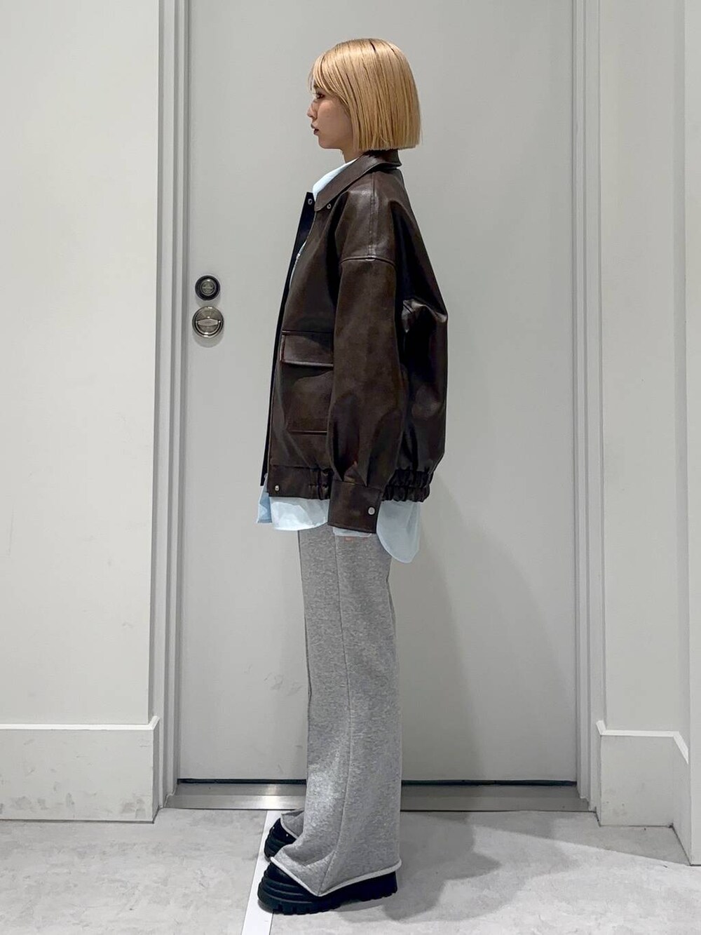 グレー系のスウェットパンツ、ブラック系のローファー、ブラウン系のブルゾンを着用したレディースの春コーディネートの3枚目の写真