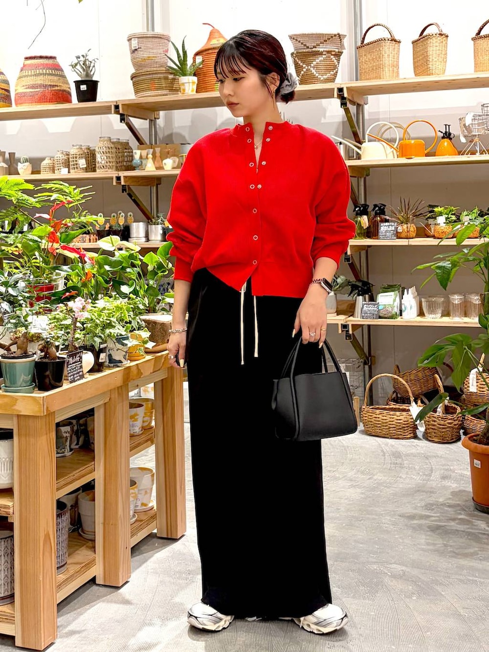 ブラック系のハンドバッグ、レッド系のカーディガン/ボレロ、ブラック系のその他パンツを着用したレディースの春コーディネートの2枚目の写真