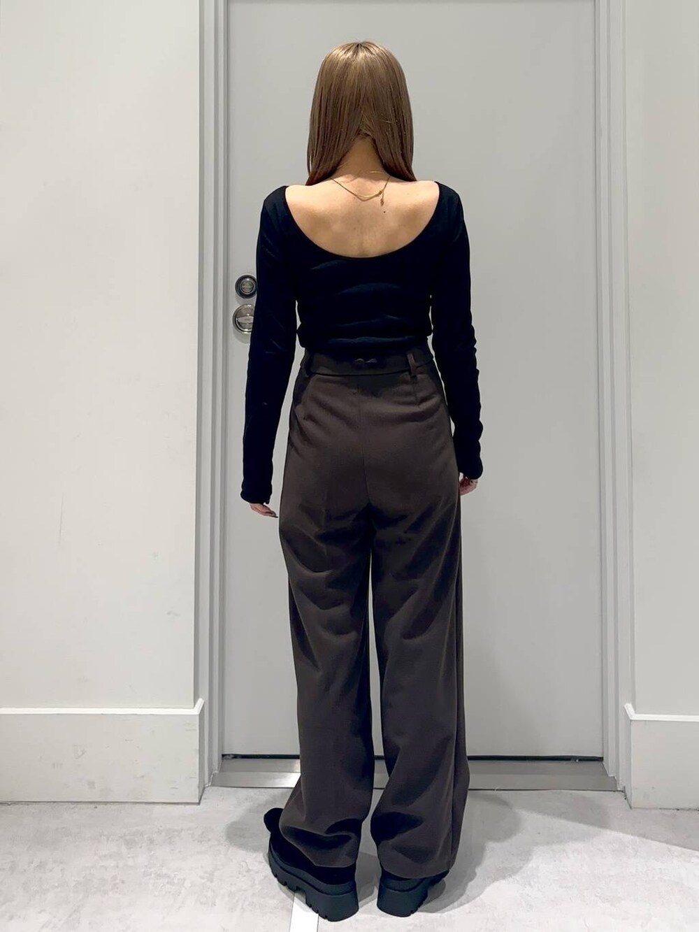 ブラック系のローファー、ブラウン系のスラックス、ホワイト系のTシャツ/カットソーを着用したレディースの冬コーディネートの3枚目の写真