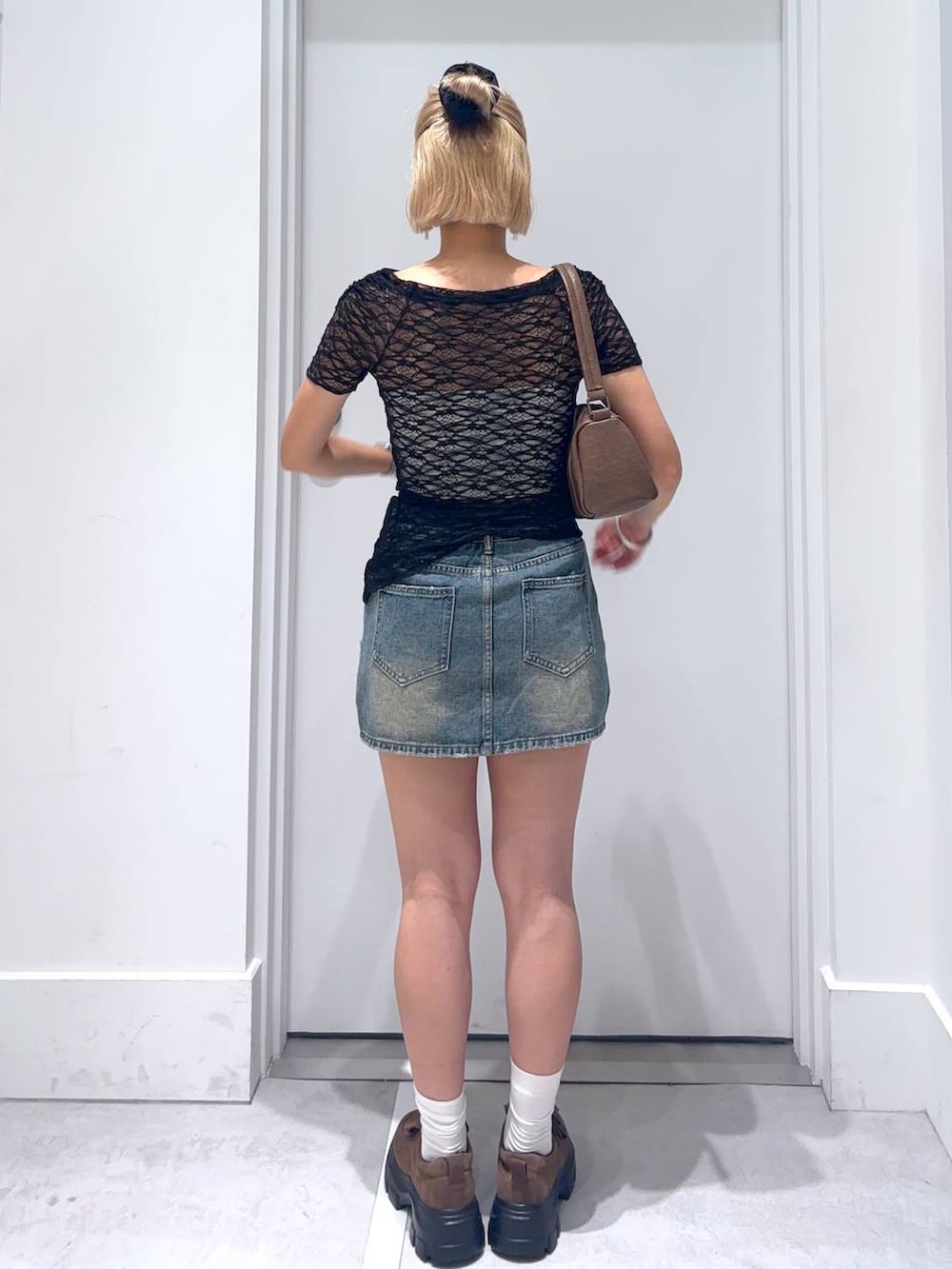 ブラック系のTシャツ/カットソー、ブラウン系のモカシン/デッキシューズ、ブルー系のデニムスカートを着用したレディースの夏コーディネートの5枚目の写真