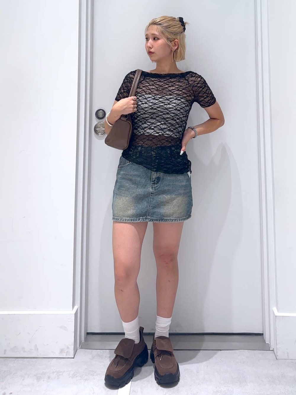 ブラック系のTシャツ/カットソー、ブラウン系のモカシン/デッキシューズ、ブルー系のデニムスカートを着用したレディースの夏コーディネートの3枚目の写真