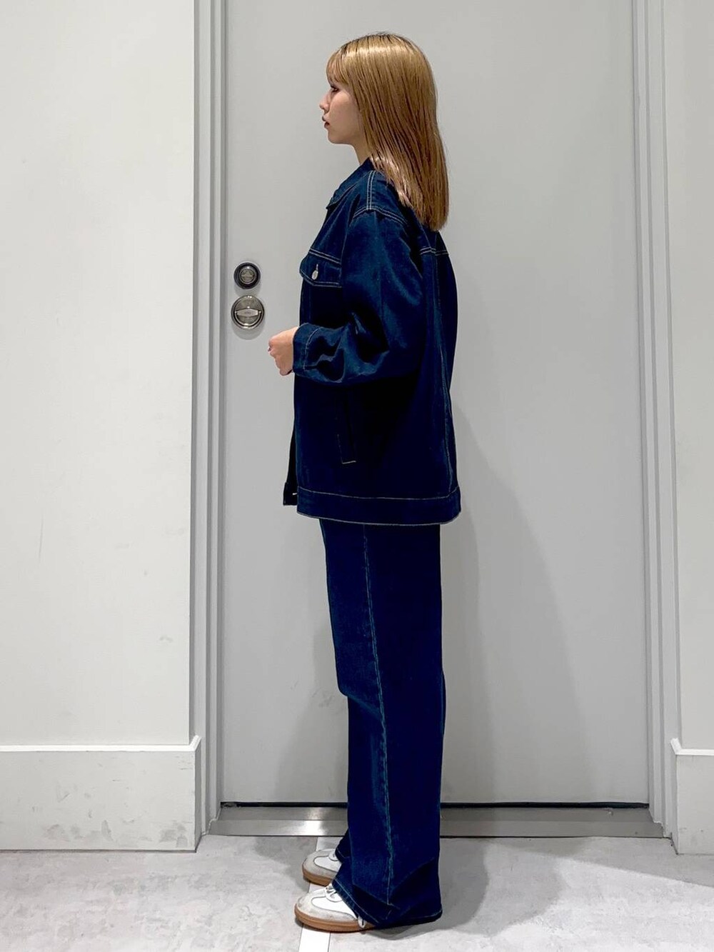 ブルー系のデニムパンツ、ゴールド系のネックレスを着用したレディースの冬コーディネートの3枚目の写真