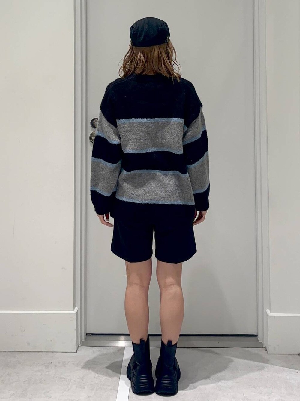 ブラック系のスラックス、ブラック系のブーツ、ブラック系のニット/セーターを着用したレディースの冬コーディネートの5枚目の写真