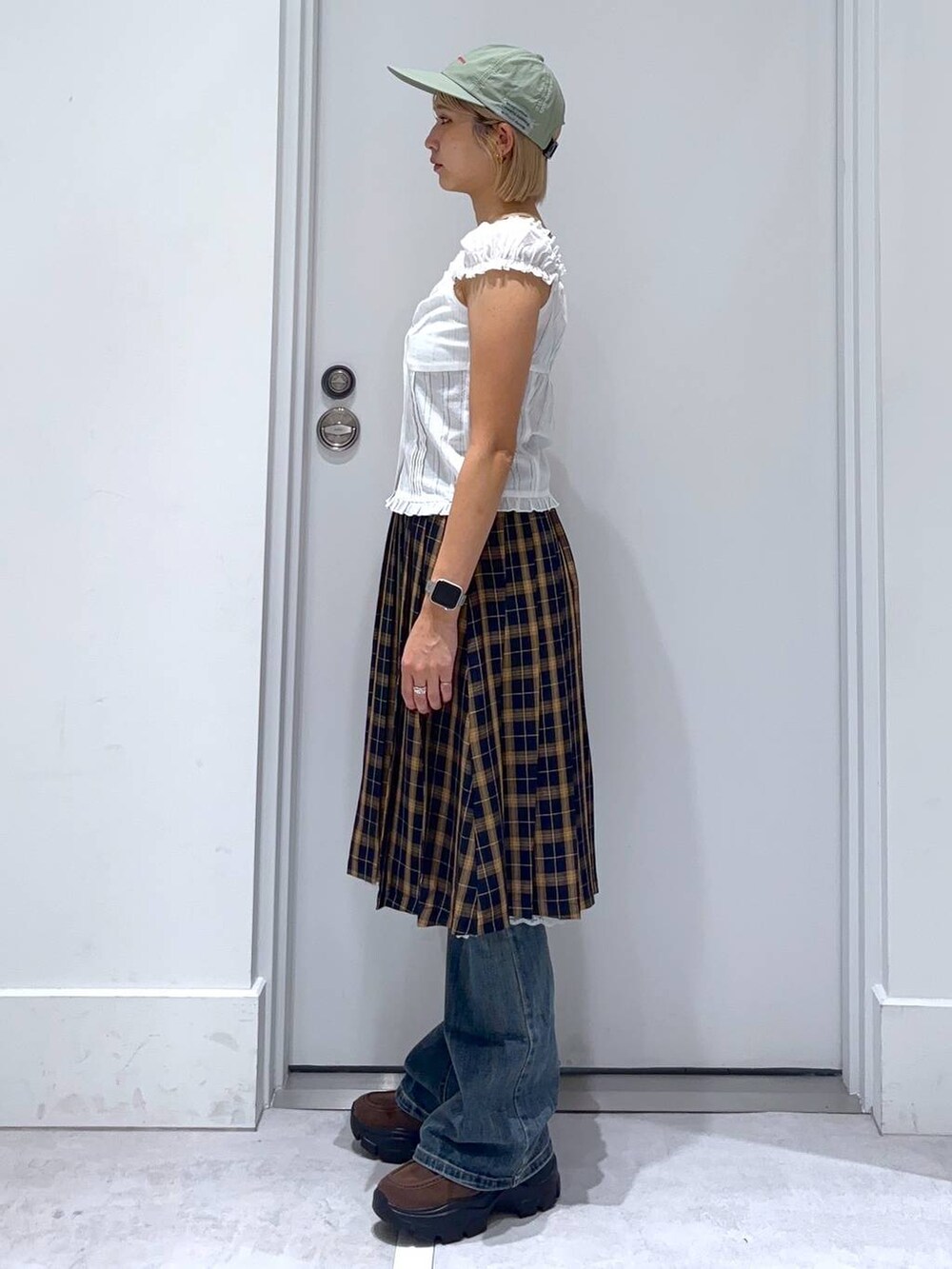 ブルー系のデニムパンツ、ブルー系のスカート、ブラウン系のモカシン/デッキシューズを着用したレディースの秋コーディネートの2枚目の写真