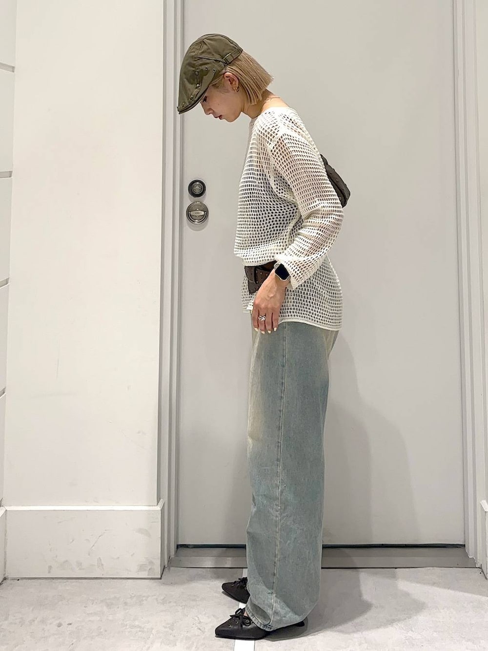 ブルー系のデニムパンツ、ブラウン系のその他シューズ、ブラウン系のハンドバッグを着用したレディースの春コーディネートの3枚目の写真