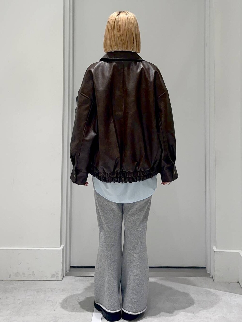 グレー系のスウェットパンツ、ブラック系のローファー、ブラウン系のブルゾンを着用したレディースの春コーディネートの4枚目の写真