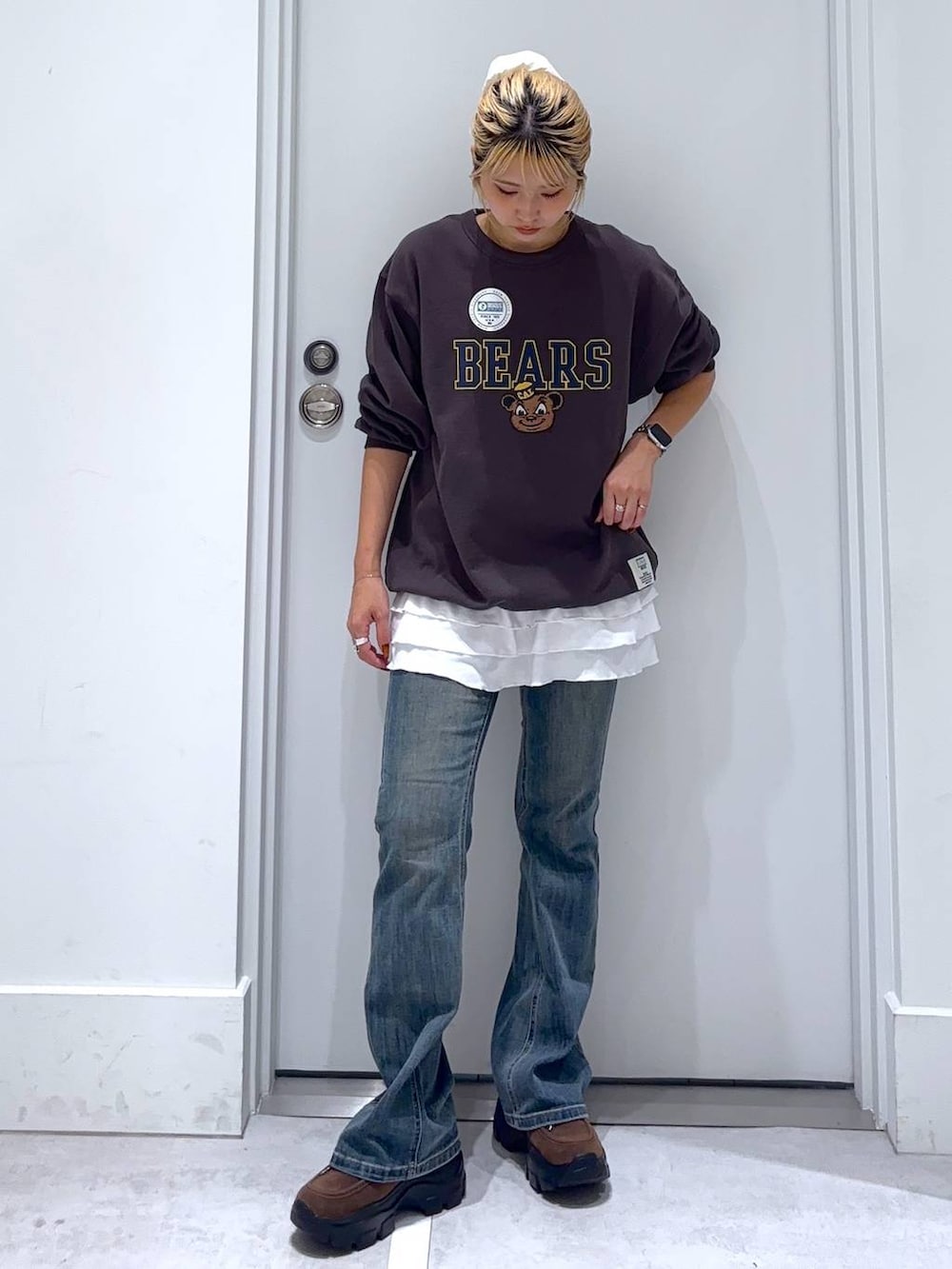 ブルー系のデニムパンツ、グレー系のスウェット、ブラウン系のモカシン/デッキシューズを着用したレディースの秋コーディネートの3枚目の写真