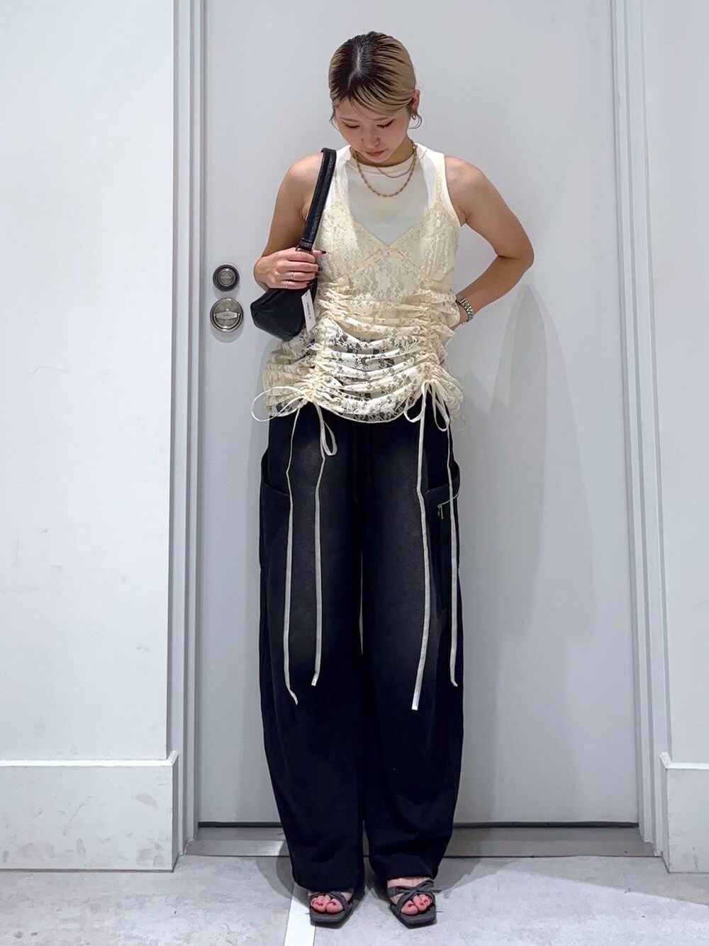 ベージュ系のワンピース、ホワイト系のタンクトップ、その他のサンダルを着用したレディースの夏コーディネートの3枚目の写真