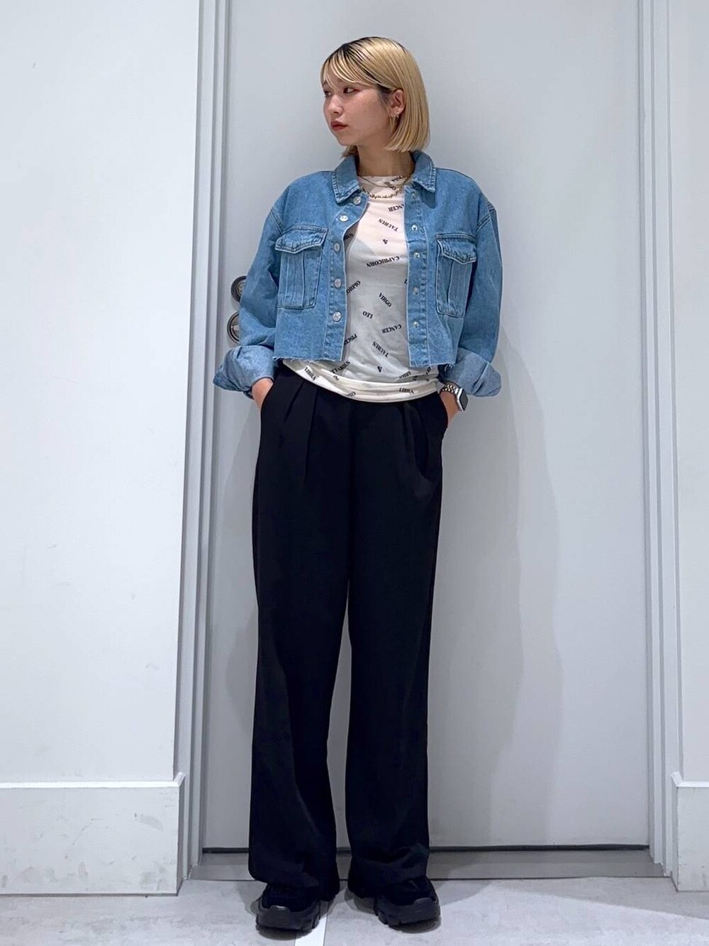 ブルー系のデニムジャケット、ブラック系のモカシン/デッキシューズ、ブラック系のスラックスを着用したレディースの秋コーディネートの2枚目の写真