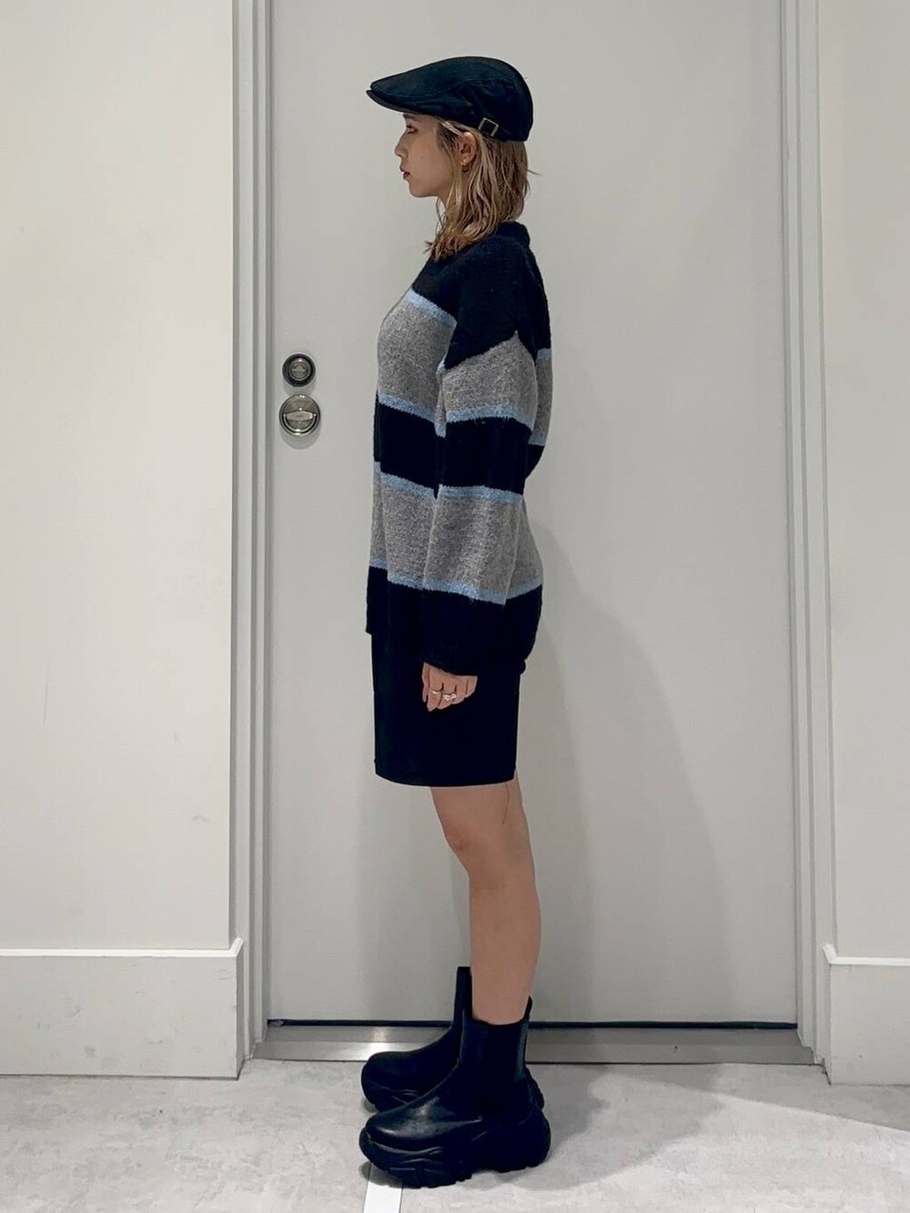 ブラック系のスラックス、ブラック系のブーツ、ブラック系のニット/セーターを着用したレディースの冬コーディネートの3枚目の写真