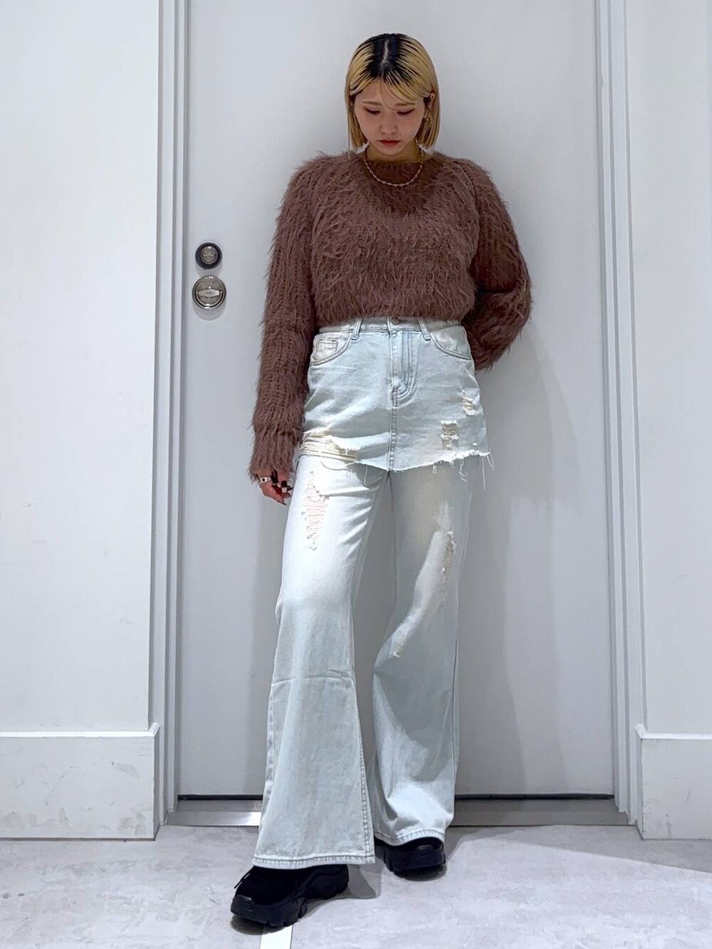 ブラウン系のニット/セーター、ブラック系のモカシン/デッキシューズ、ブルー系のデニムパンツを着用したレディースの秋コーディネートの3枚目の写真