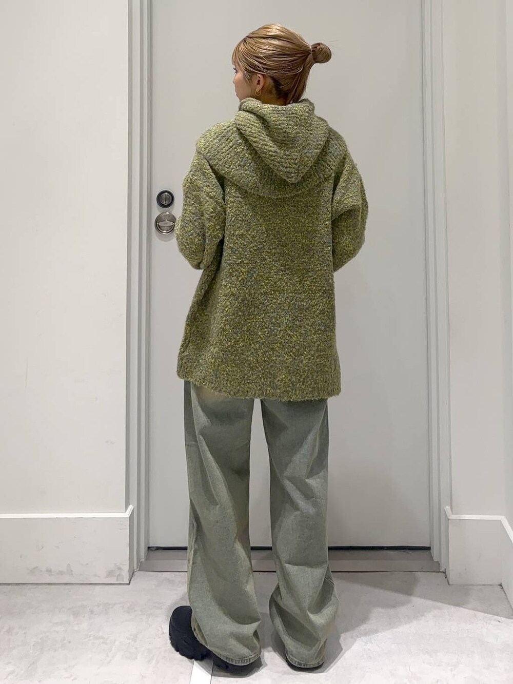 ブルー系のデニムパンツ、グリーン系のニット/セーターを着用したレディースの冬コーディネートの4枚目の写真
