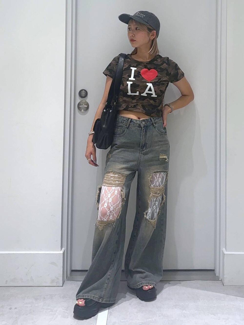ブラック系のサンダル、その他のTシャツ/カットソー、ブルー系のデニムパンツを着用したレディースの夏コーディネートの2枚目の写真