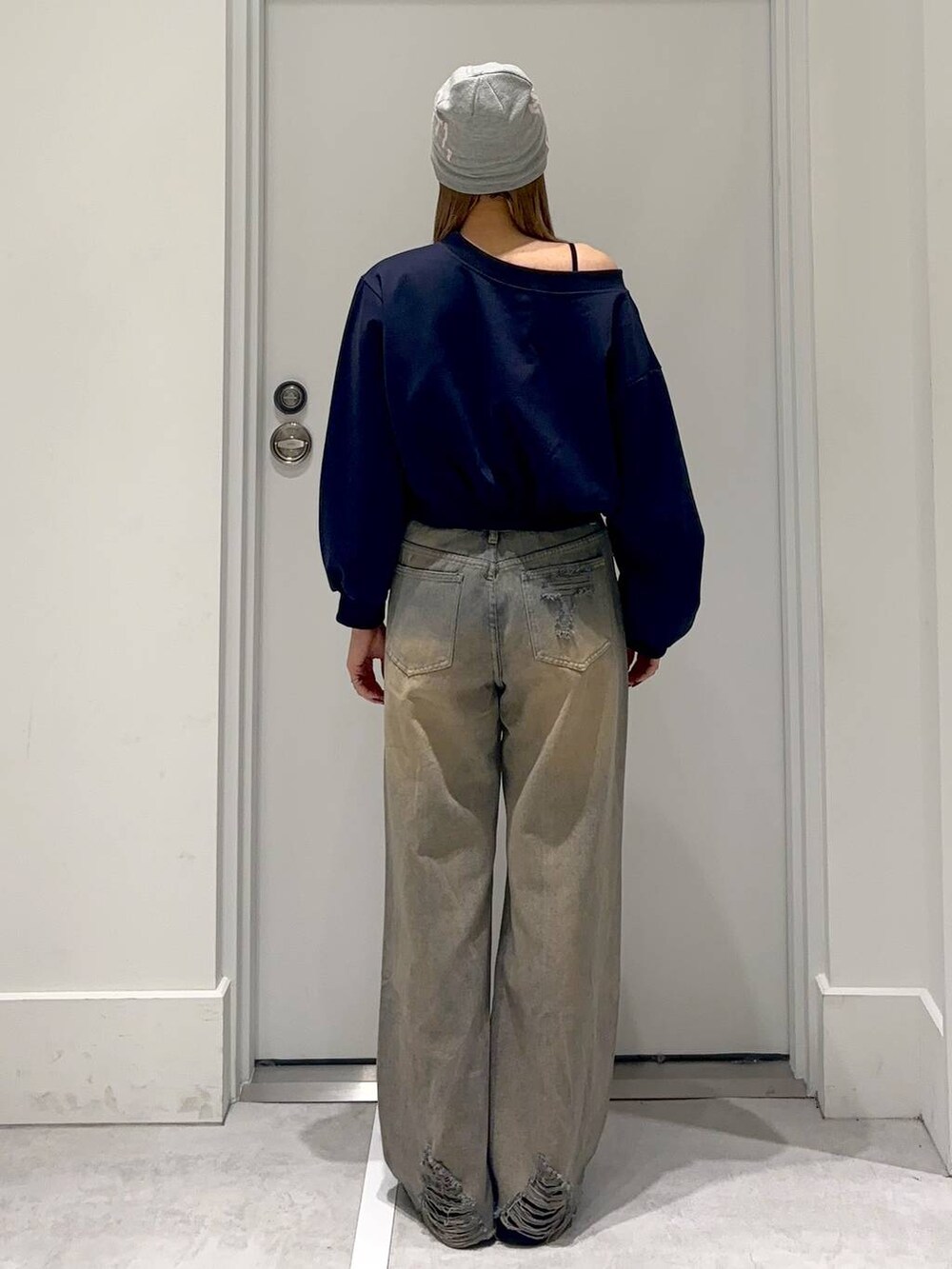 ブラック系のスリッポン、ブルー系のスウェット、ブルー系のデニムパンツを着用したレディースの冬コーディネートの5枚目の写真