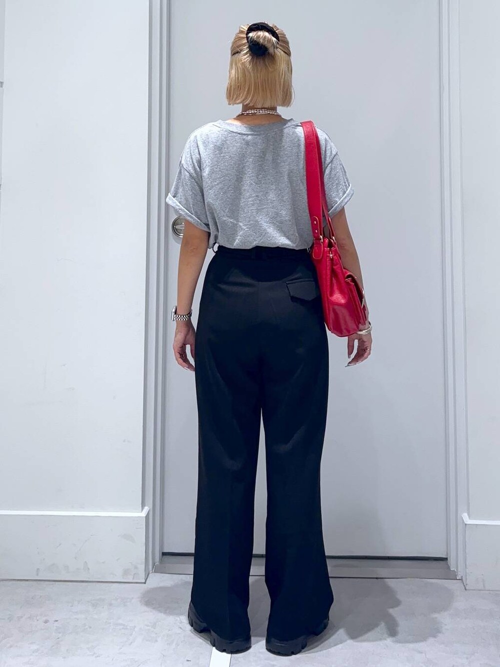 ブラウン系のモカシン/デッキシューズ、グレー系のTシャツ/カットソー、ブラック系のスラックスを着用したレディースの夏コーディネートの5枚目の写真