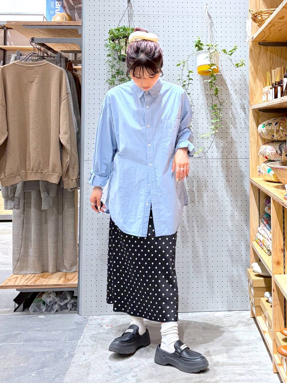 ブラック系のスカート、ブルー系のシャツ/ブラウス、ホワイト系のソックス/靴下を着用したレディースの春コーディネートの2枚目の写真