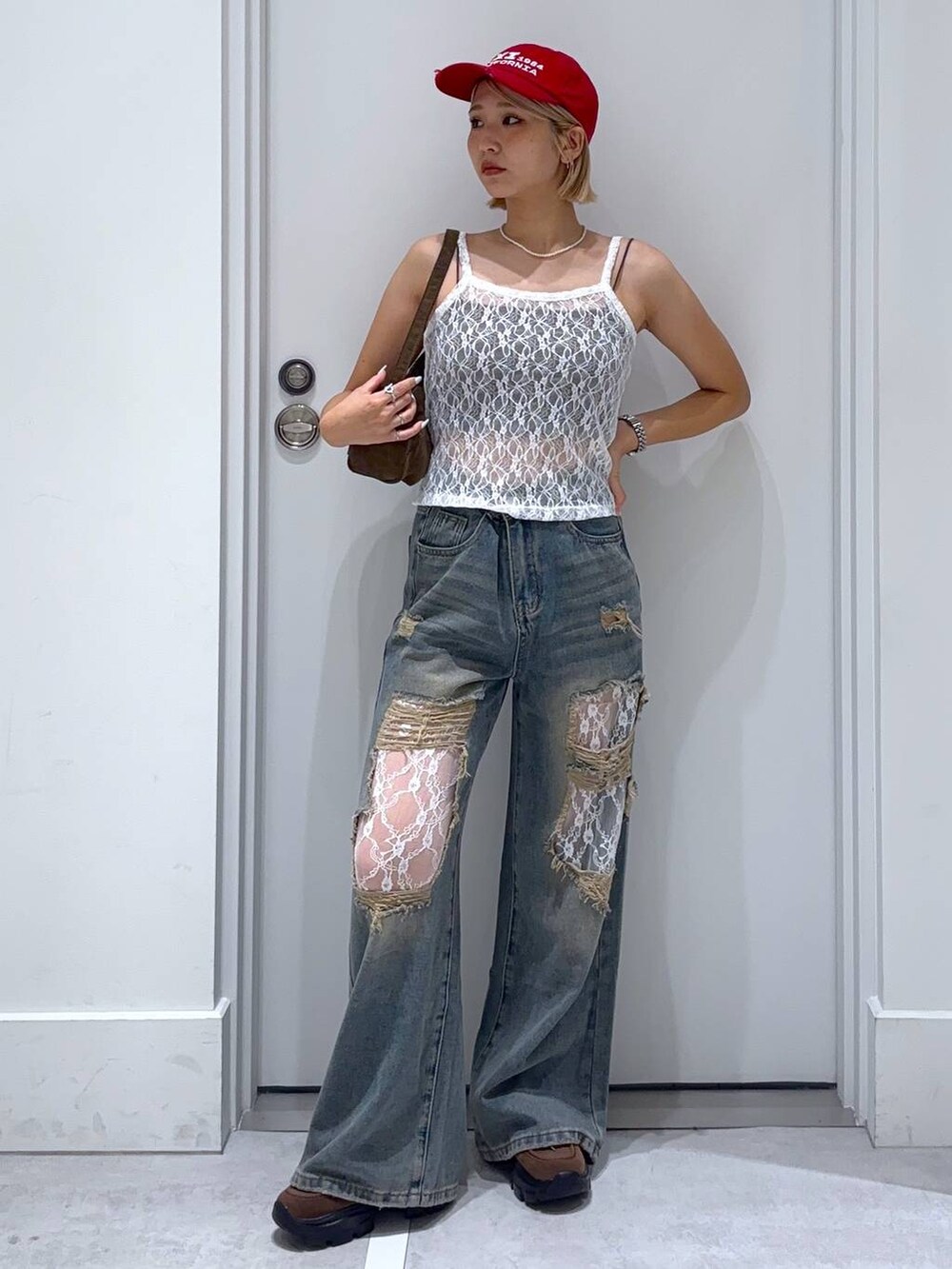 ブラウン系のキャミソール、ブルー系のデニムパンツ、ブラウン系のモカシン/デッキシューズを着用したレディースの夏コーディネートの3枚目の写真