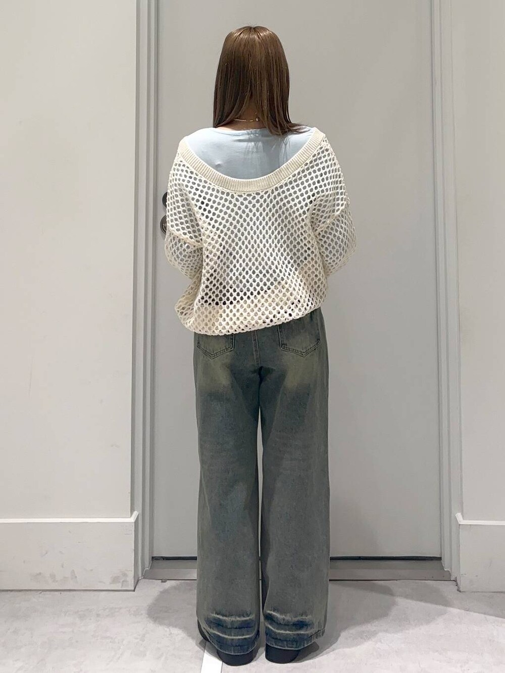 ブラック系のブーツ、ブルー系のTシャツ/カットソー、ブルー系のデニムパンツを着用したレディースの冬コーディネートの4枚目の写真