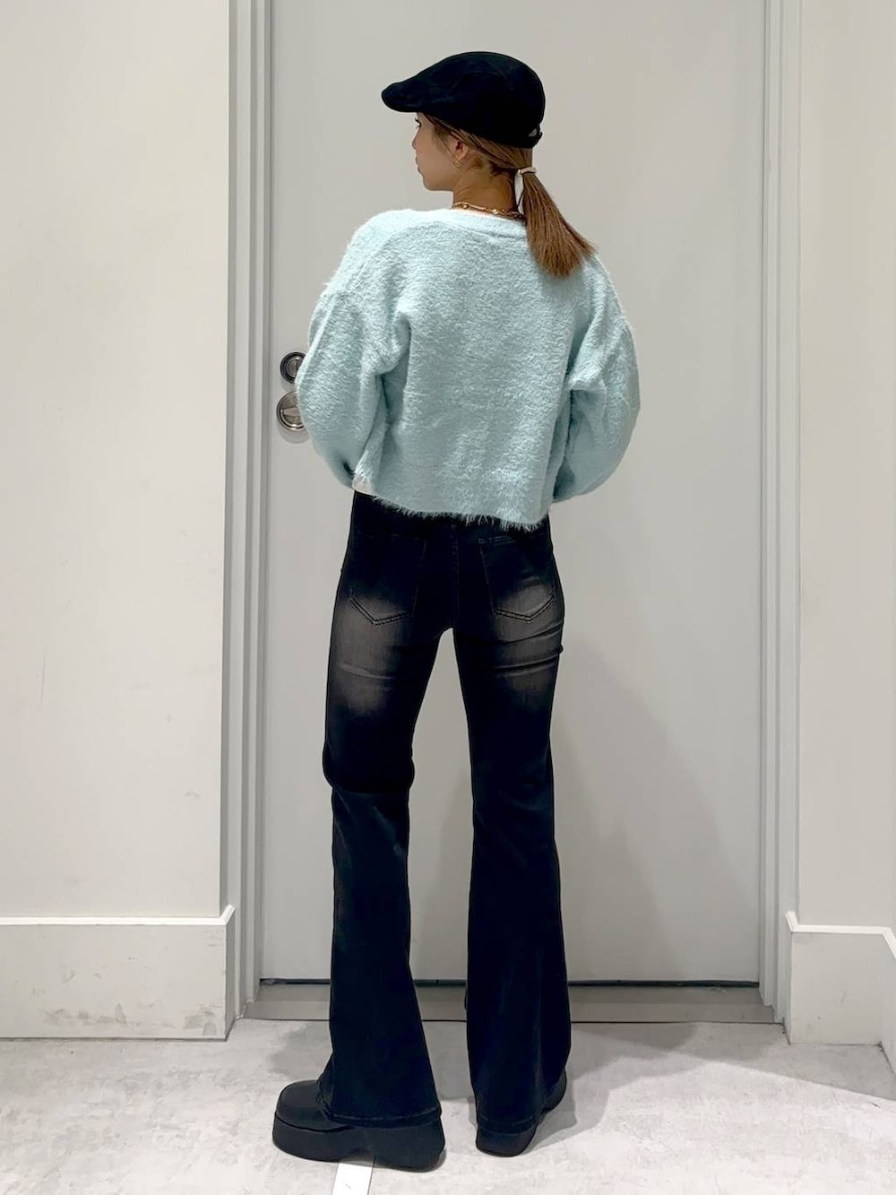 ブルー系のカーディガン/ボレロ、ブラック系のスリッポン、ブラック系のデニムパンツを着用したレディースの冬コーディネートの4枚目の写真