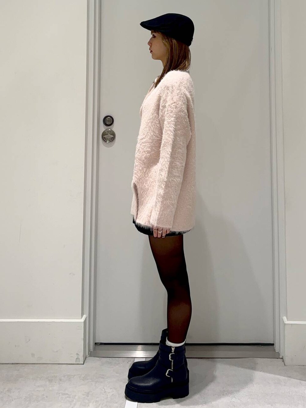 ブラック系のスカート、ピンク系のチュニック、ブラック系のハンチング/ベレー帽を着用したレディースの冬コーディネートの3枚目の写真