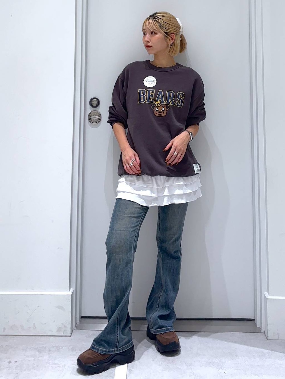 ブルー系のデニムパンツ、グレー系のスウェット、ブラウン系のモカシン/デッキシューズを着用したレディースの秋コーディネートの4枚目の写真