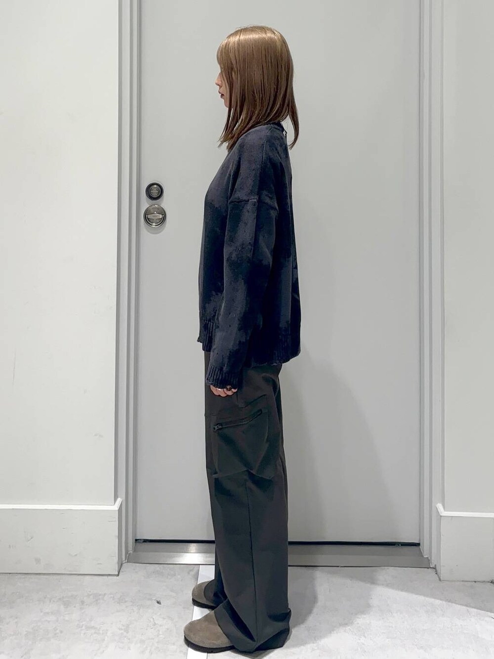 グリーン系のカーゴパンツ、グレー系のニット/セーターを着用したレディースの冬コーディネートの3枚目の写真