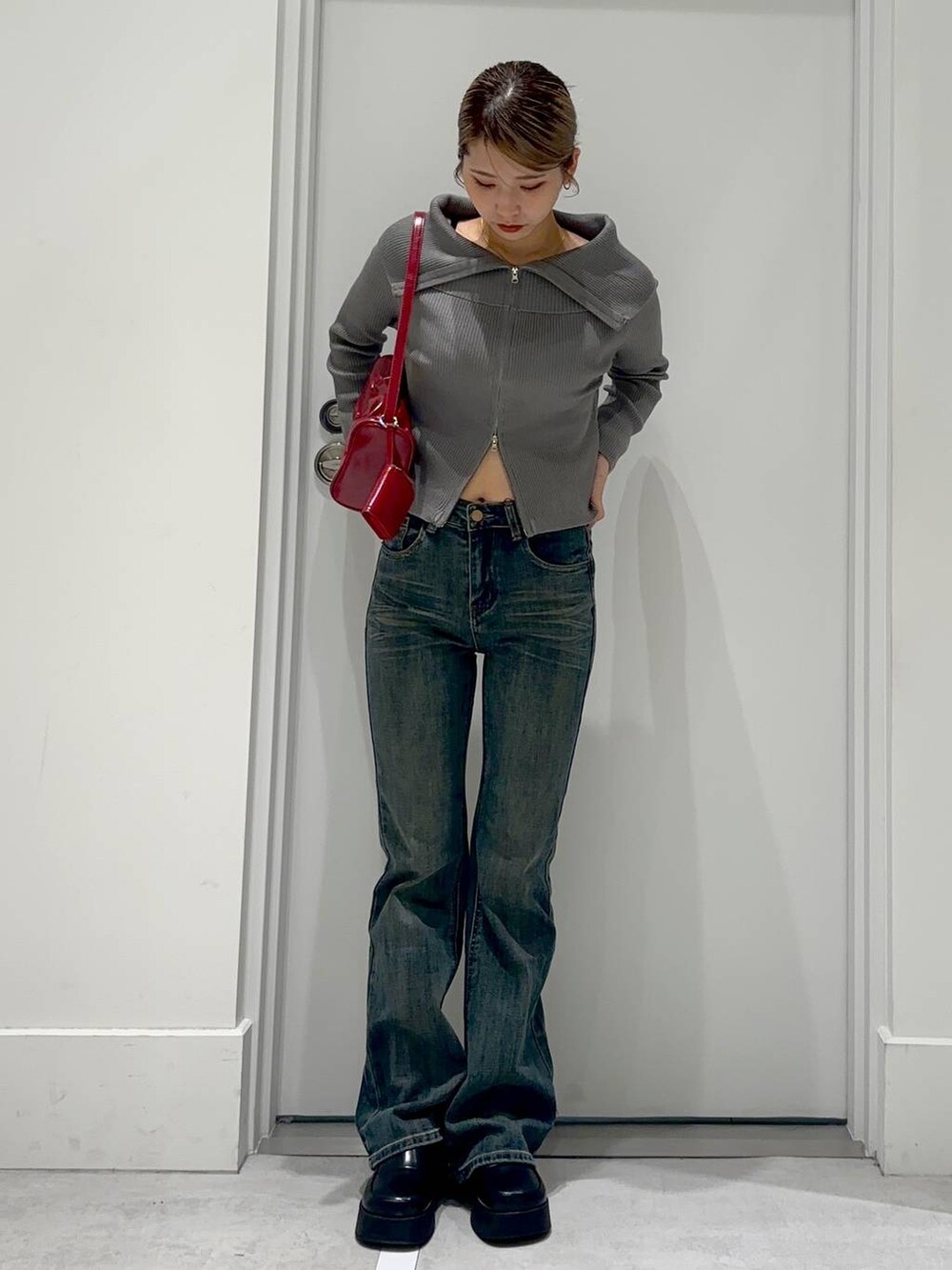 ベージュ系のカーディガン/ボレロ、ブラック系のスリッポン、レッド系のショルダーバッグを着用したレディースの秋コーディネートの2枚目の写真