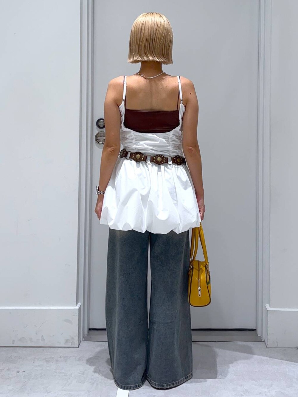 ブラウン系のキャミソール、ブラック系のその他シューズ、イエロー系のボストンバッグを着用したレディースの夏コーディネートの4枚目の写真