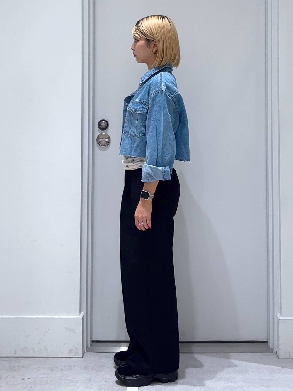 ブルー系のデニムジャケット、ブラック系のモカシン/デッキシューズ、ブラック系のスラックスを着用したレディースの秋コーディネートの3枚目の写真